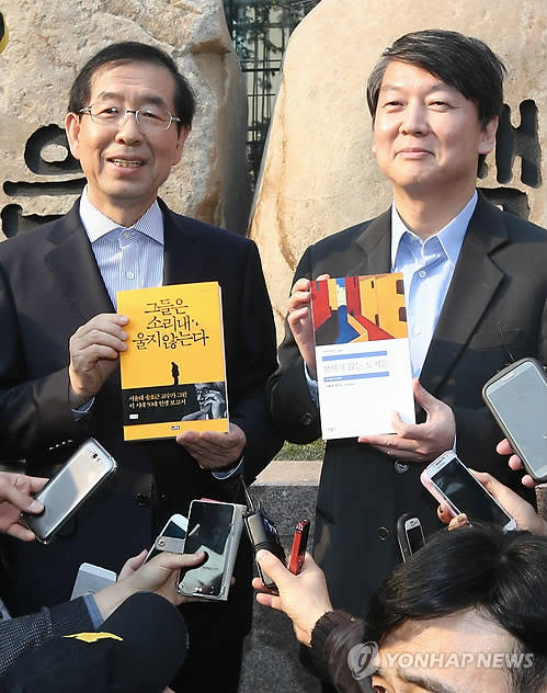 박원순 서울시장과 안철수 새정치민주연합 공동 창당준비위원장이 23일 오후 서울 교보문고 앞에서 서로에게 선물할 책을 들고 기념사진을 찍고 있다. 박 시장은 안 의원에게 '그들은 소리내 울지 않는다'를 안 의원은 박 시장에게 '보이지 않는 도시들'을 선물했다.(사진=연합뉴스)
