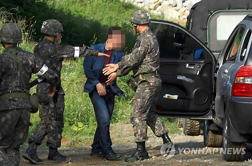 23일 오전 강원도 고성군 현내면 대진리와 마달리를 연결하는 교차로에서 임모 병장의 아버지가 군 관계자와 대화하고 있다. 2014.6.23 (사진=연합뉴스)