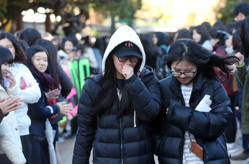 대학수학능력시험을 하루 앞둔 12일 오전 서울 종로구 풍문여고 1,2학년 학생들이 수험표를 받고 나오는 수험생 선배들에게 응원의 메시지를 전하고 있다. 사진 = 연합뉴스