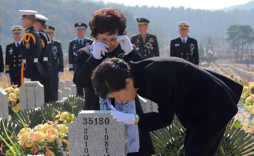 박근혜 대통령이 26일 오전 국립대전현충원에서 열린 천안함 용사 5주기 추모식에 앞서 46용사 묘역을 찾아 고 박경수 상사의 어머니 이기옥 씨 등 유가족을 위로한 뒤 묘비를 어루만지고 있다.(사진=연합뉴스)
