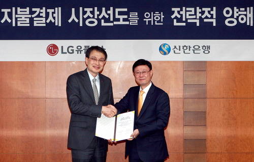 26일 신한은행 본점에서 열린 핀테크 사업선도를 위한 전략적 제휴 업무협약식을 마치고 신한은행 유동욱 부행장(오른쪽)과 LG유플러스 강문석 부사장(왼쪽)이 기념 촬영하는 모습. (사진제공=신한은행)