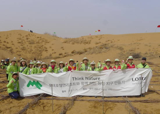 지난 29일 중국 내몽고 쿠부치 사막에서 남재섭 상무(오른쪽에서 네번째)를 비롯한 롯데호텔 임직원과 미래숲 그린코어 일동이 기념촬영을 하고 있다. (사진제공=롯데호텔)