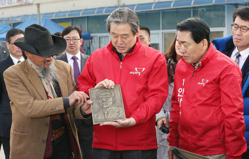 새누리당 김무성 대표와 4·29 국회의원 재보궐선거 인천 서구·강화군을 지역에 출마한 안상수 예비후보가 7일 오전 인천시 강화군 강화풍물시장에서 우연히 발견한 박정희 전 대통령 동판을 살펴보고 있다.(사진=연합뉴스)