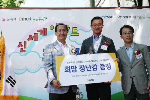 16일 복조리시장에서 희망장난감도서관 37호점 개관 기념식이 열린 가운데 이원회 이마트 천호점장(가운데)이 육근목 길동복조리시장 상인회장(좌측)에게 희망 장난감 증정패를 전달하고 있다. (사진=신세계)