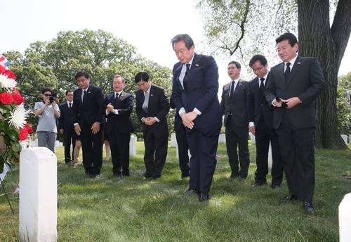 미국을 방문 중인 새누리당 김무성 대표(가운데)와 동행 의원들이 26일(현지시간) 워싱턴 D.C 알링턴 국립묘지 내 6·25전쟁 영웅인 워커 장군의 묘비에 절하고 있다. 오른쪽 부터 강석호, 김영우, 김학용, 김무성, 장윤석, 양창영, 심윤조 의원.(사진=연합뉴스)