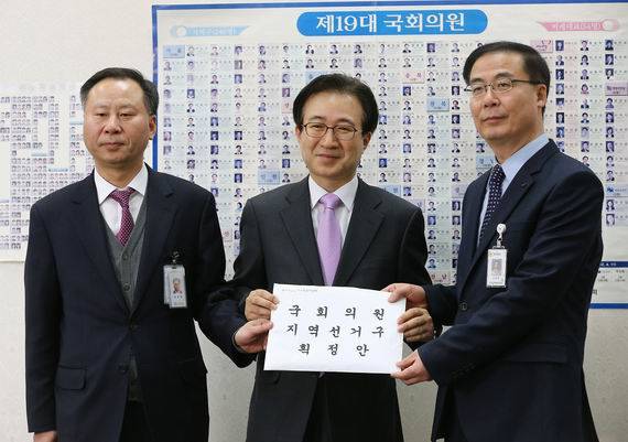 여야가 20대 총선 선거구 획정안에 합의해 국회 통과를 앞두고 있다. 지역구를 7석 늘려 기득권 챙기기라는 비판이 일고 있는 가운데, 이런 분위기를 타고 테러방지법도 함께 통과될 것으로 보는 시각이 많다. 김세환 중앙선거관위 선거구획정위원회 사무국장(오른쪽)이 28일 국회 의장실을 찾아 이명우 의장실 정무수석 비서관(가운데)에게 선거구획정안을 제출하고 있다. (사진=연합뉴스)