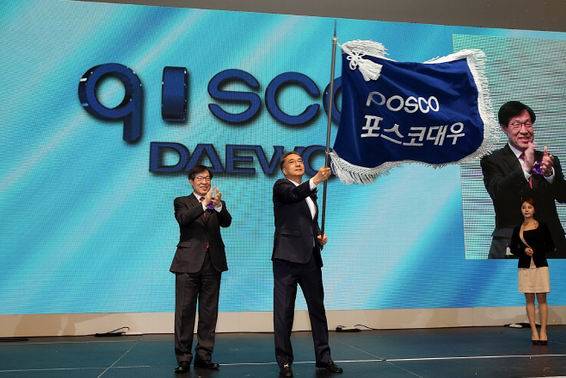 지난 21일 인천 송도컨벤시아에서 진행된 포스코대우(구 대우인터내셔널) CI 선포식에서 김영상 포스코대우 사장(오른쪽)이 새 사명이 적힌 깃발을 흔들고 있다. 김 사장 왼편이 권오준 포스코 회장. (사진=포스코대우)