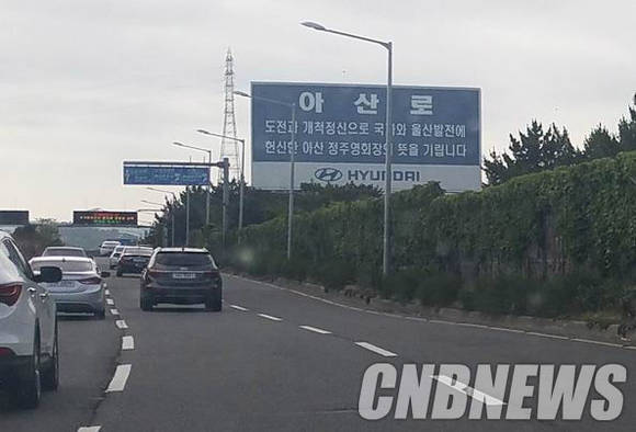 울산 방어진 순환도로(아산로)변에 설치된 대형표지판. 고(故) 정주영 회장의 개척정신을 기리자는 문구가 위기의 울산 현실과 맞물리며 여운을 남긴다. (사진=도기천 기자)
