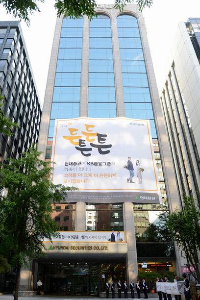 현대증권을 품에 안은 KB금융이 거대 통합증권사 출범에 속도를 내고 있다. 사진은 현대증권 여의도 본사 사옥. ‘KB금융과 한가족이 되었다’는 내용의 플래카드가 걸려 있다. (KB금융 제공)