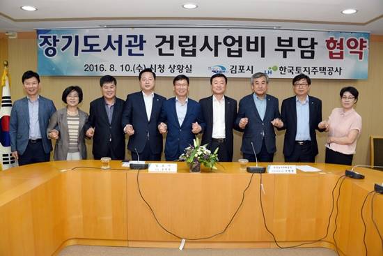 더민주 김두관 의원(왼쪽네번째)이 장기도서관 건립사업비 112억원 부담 협약을 이끌어냈다(사진= 김두관 의원실)