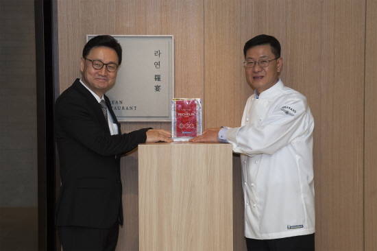 서울신라호텔의 조정욱 총지배인(왼쪽), 김성일 라연 책임주방장이 한식당 라연 앞에서 미슐랭 3스타 선정 인증패 기념 촬영을 하고 있다. (사진=호텔신라)