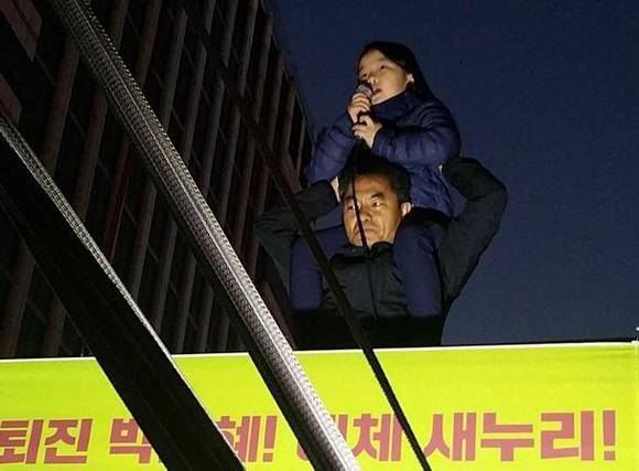 지난 12일 민중총궐기 대회에서 한 초등학생이 아빠의 무등을 타고 “거짓말한 대통령 물러나세요”라고 외치고 있다. (사진=도기천 기자)