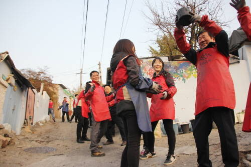 봉사단과 함께 연탄을 배달하고 있는 김치현 롯데건설 대표이사(오른쪽). (사진=롯데건설)