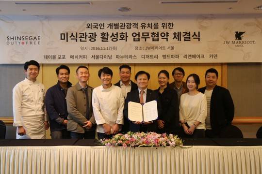 김성겸(오른쪽 다섯번째) 신세계디에프 영업담당과 유명셰프 9인이 JW메리어트서울에서 미식관광 활성화를 위한 상호 업무협약을 체결하고 있다. (사진제공=신세계면세점)