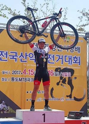 '제3회 양산시장배 전국산악자전거 대회' 에서 1위를 차지한 창원대 사이클부 김재휴 선수가 시상식에서 자신의 자전거를 들어 올리고 있다. (사진제공=창원대)
