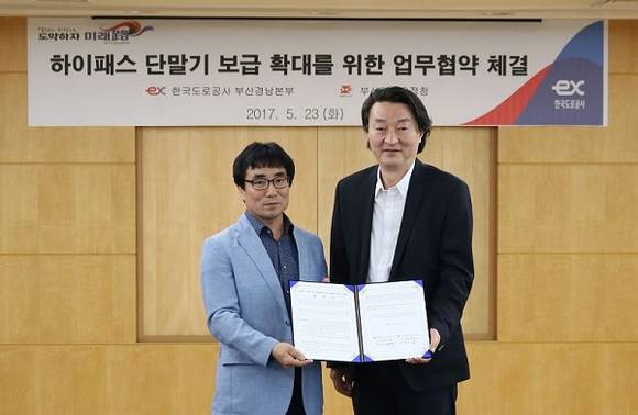 23일 박문규 한국도로공사 부산경남본부장(사진 왼쪽)과 전성무 부산지방우정청장(사진 오른쪽)이 하이패스 단말기 보급 확대를 위한 업무협약을 체결하고 기념촬영을 하고 있다. (사진제공=한국도로공사)