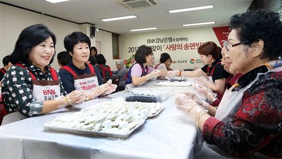 손교덕 은행장 부인 송혜경 여사(사진 왼쪽 첫번째)와 한경호 경남도지사 권한대행 부인 김미순 여사(사진 왼쪽 두번째)를 비롯한 자원봉사자들이 지난 22일 송편을 빚고 있다. (사진제공=BNK경남은행)