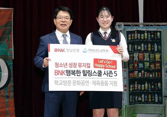 BNK경남은행 손교덕 은행장(사진 왼쪽)이 30일 마산무학여자고등학교 조윤수 학생회장에게 '체육용품 지원증서' 를 전달한 뒤 기념촬영하고 있다. (사진제공=경남은행)