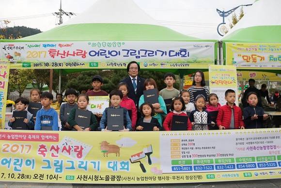 사천축협 진삼성 조합장(가운데)이 지난 28일 그림그리기 대회 아이들과 기념촬영 하고 있다. (사진제공=경남농협)