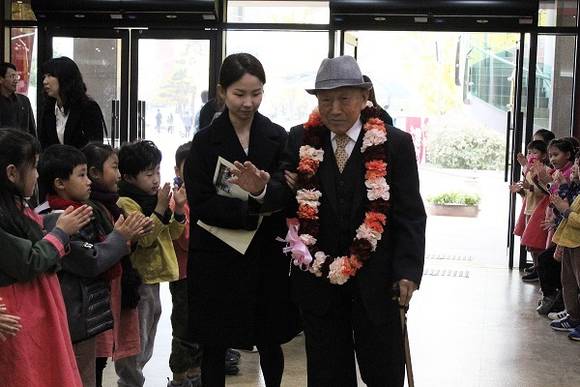 제78회 순국선열의날 기념식, 법륜유치원 원생들의 환영을 받고 있는 김병길 지사님. (사진제공=부산지방보훈청)