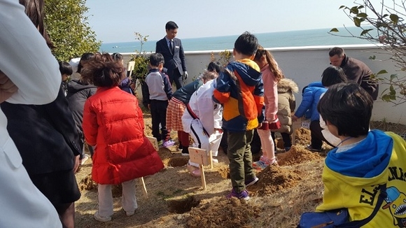 23일 기장군 드림스타트 아동들이 묘목을 심고있다. (사진제공=기장군)