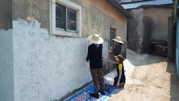창원시 진해구 태평동 장옥거리 벽화조성사업 봉사활동에 참여한 창원대학교 LINC+사업단 교직원들이 벽화를 그리고 있다. (사진제공=창원대)