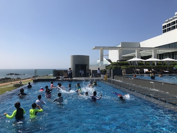 기장군드림스타트 아동들이 힐튼 부산 야외수영장에서 물놀이를 즐기고 있는 모습. (사진=기장군)