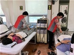 '헬시 봉사팀'이 물리치료실 이용자들을 케어하는 모습. (사진=김해시)