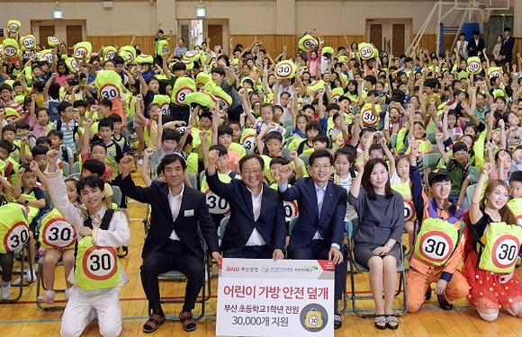 5일 부산 창신초등학교에서 (오른쪽부터) 초록우산 어린이재단 이수경 부산본부장, 빈대인 부산은행장, 김석준 부산시교육감이 참석한 가운데 스쿨존의 안전사고를 방지할 수 있는 '어린이 가방 안전 덮개' 전달식이 열렸다. (사진=부산은행)