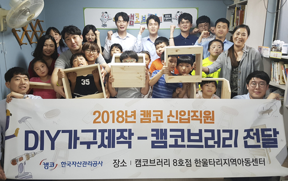 캠코 신입직원들이 직접 제작한 학습용 DIY 가구를 캠코브러리 8호점(부산 부전동 소재 한울타리 지역아동센터)에 전달하고 기념촬영을 하고 있다. (사진제공=캠코)