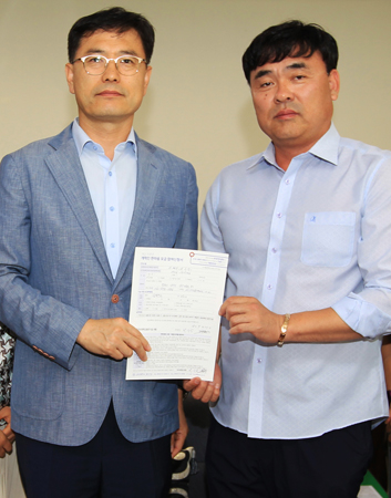 경상대 교직원으로 근무하다 퇴직 후 사망한 고 이혜진 씨의 부군 박수창 씨(오른쪽)가 정우식 대외협력본부장에게 발전기금을 전달한 뒤 기념촬영을 하고 있다. (사진제공=경상대)