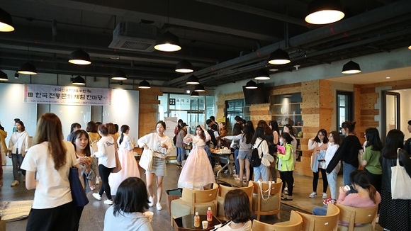 한국 전통문화 체험 한마당 행사에 참석한 외국인 유학생들이 한복 입기 체험과 전통 음식 맛보기 체험을 하고 있다. (사진=부산외대)