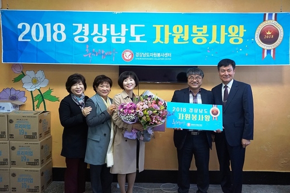 올해 9월의 '경상남도 자원봉사왕'에 선정된 허임정(왼쪽 3번째) 씨가 꽃다발을 들고 기념촬영을 하고 있다. (사진=밀양시)