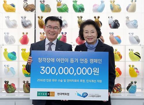 현대백화점 김영태 사장(왼쪽)이 사랑의달팽이 김민자 회장에게 청각장애 어린이 돕기 기금 3억원을 전달하고 있다. (사진=현대백화점)
