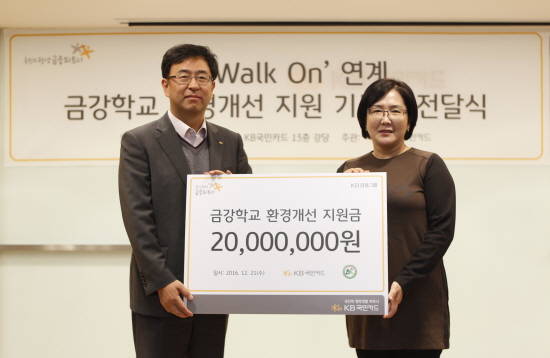 21일 서울 종로구 KB국민카드 본사에서 백문일 KB국민카드 상무(왼쪽)가 주명화 금강학교 교장(오른쪽)에게 기부금을 전달한 후 기념 촬영을 하고 있다. (사진=KB국민카드)