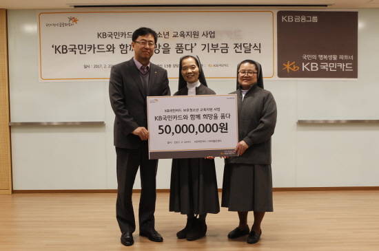 22일 서울 종로구 KB국민카드 본사에서 백문일 KB국민카드 브랜드전략부 상무(왼쪽)가 사회복지법인 살레시오수녀회 마자렐로센터 원장 오옥순 수산나 수녀(가운데)에게 보호수감시설 청소년 교육 및 자립 지원을 위한 후원금 5000만원을 전달하고 있다. (사진=KB국민카드)