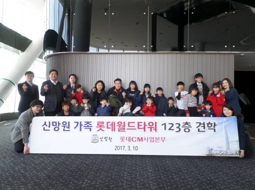 롯데월드타워 견학 기념촬영 중인 신망원 가족들과 롯데건설 CM사업본부 관계자들. (사진=롯데건설)