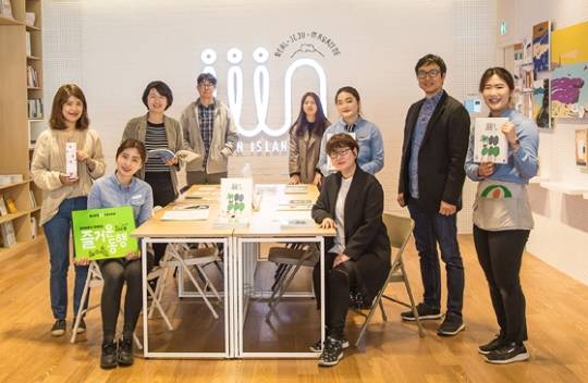 올리브영 제주탑동점 내 제주인스토어(iiin Store)에서 올리브영 직원들과 고선영 재주상회 대표(앞쪽 우측 착석자), 참여 아티스트들이 함께 포즈를 취하고 있다. (사진=CJ올리브네트웍스)