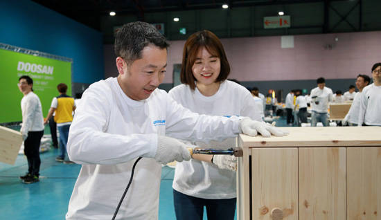 박정원 두산그룹 회장이 ‘두산인 봉사의 날(Doosan Day of Community Service)’을 맞아 서울무역전시컨벤션센터에서 임직원들과 함께 지역사회 가정에 전달할 가구를 만들고 있다. (사진=두산)