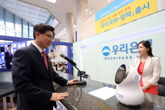 24일 이광구 우리은행장이 '우리 로보-알파'를 탑재한 실물 로봇을 통해 자산관리 상담을 받고 있다. (사진=우리은행)
