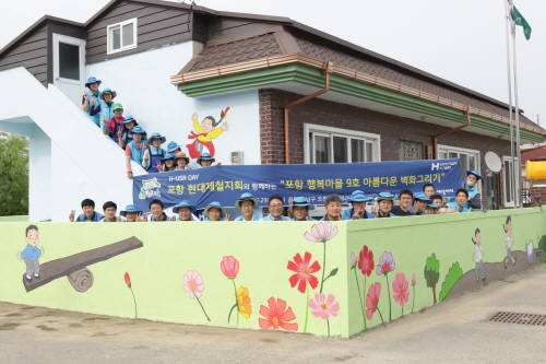 지난 23일 봉사활동에 참가한 봉사자들이 자신들이 그린 벽화 앞에서 기념촬영에 임하고 있다. (사진=현대제철)