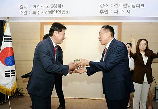 김동규 경기도의원(자유한국당 파주시을 지역위원장)이 이순우 파주시 장애인연합회장으로부터 감사패를 받고 있다(사진= 김진부 기자)