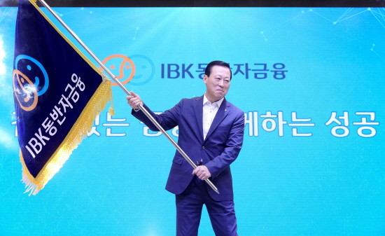 1일 창립 56주년 기념식 행사 중 열린 ‘동반자금융 브랜드 선포식’에서 김도진 기업은행장이 브랜드기를 흔들고 있는 모습. (사진=기업은행)