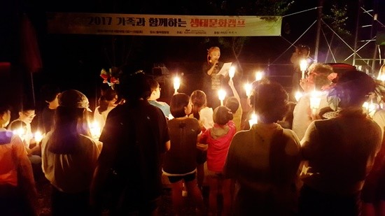 18일 밤 시인 로즈박이 '아이와 꿈꾸는 숲' 촛불 퍼포먼스를 진행하고 있다(사진= 김진부 기자)
