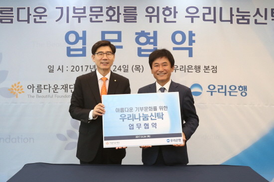 24일 서울 중구 우리은행 본점에서 진행된 ‘우리은행-아름다운재단과 기부문화 확산을 위한 우리나눔신탁 업무협약’에서 이광구 우리은행장(사진 왼쪽)이 박종문 아름다운재단 이사장과 업무협약을 체결한 뒤 기념촬영을 하고 있다. (사진=우리은행)