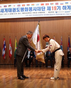 이중근 회장이 봉사단 대표로부터 단기를 전달받고 있다. (사진=부영그룹)