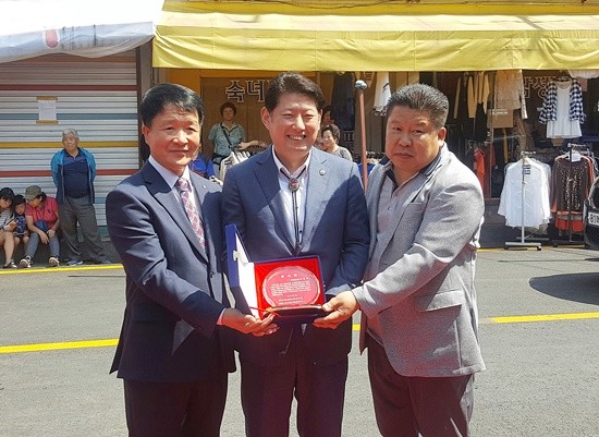 김동규 의원(가운데)이 금정로시장 안대성 회장과 명동로시장 한진구 회장으로부터 감사패를 받고 기념촬영하고 있다(사진= 김동규 의원실)