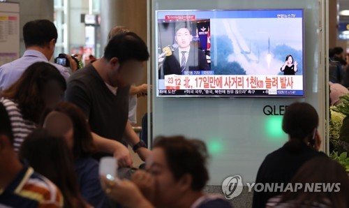 북한이 북태평양을 향해 일본 상공으로 탄도미사일을 발사하는 대형 도발을 감행한 15일 인천공항 입국장에서 여행객들이 관련 뉴스에 무덤덤한 모습을 보이고 있다. 사진 = 연합뉴스
