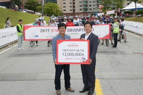 롯데카드가 16일 강원도 원주시에서 열린 ‘2017 롯데카드 그란폰도 in 오크밸리’ 대회에서 참가자 주행거리 1km당 100원씩 적립해 조성한 기금 1200만원을 원주시에 기부했다. 사진 좌측부터 롯데카드 박두환 마케팅본부장, 원주시 서경원 부시장. (사진=롯데카드)