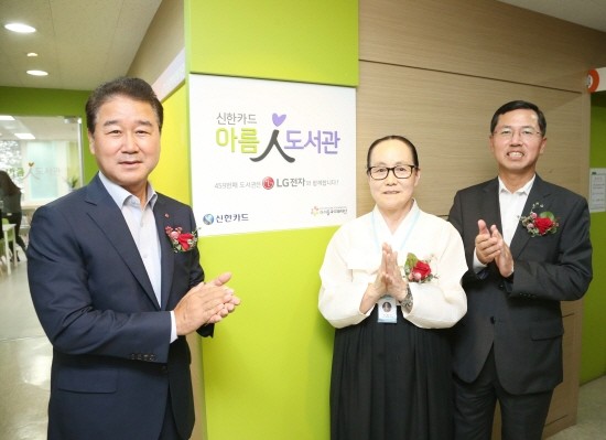 임영진 신한카드 사장(오른쪽)과 최상규 LG전자 사장(왼쪽), 이정숙 노원1종합사회복지관장(가운데)이 아름인 도서관 현판 제막 후 기념사진을 찍고 있다. (사진=신한카드)